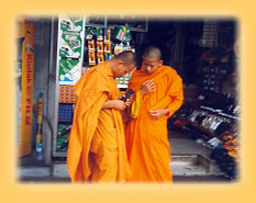 Moenche vor einem Fotoladen in Bangkok